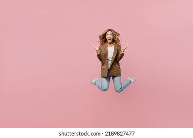 Full Body Young Shocked Amazed Happy Successful Employee Business Woman 30s She Wear Casual Brown Classic Jacket Jump High Spread Hands Isolated On Plain Pastel Light Pink Background Studio Portrait