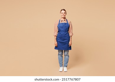 Full body young smiling happy woman barista bartender barman employee she wear blue apron red shirt work in coffee shop look camera isolated on plain beige background. Small business startup concept - Powered by Shutterstock