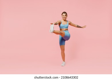 Full Body Young Strong Sporty Athletic Fitness Trainer Instructor Woman Wear Blue Tracksuit Spend Time In Home Gym Do Exercise Raise Leg Isolated On Plain Light Pink Background. Workout Sport Concept.