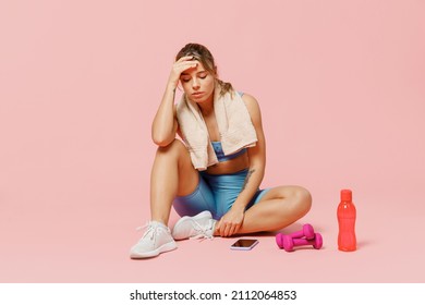 Full Body Young Strong Sporty Athletic Fitness Trainer Instructor Woman Wear Blue Tracksuit Spend Time In Home Gym Sit On Floor Hold Head Isolated On Plain Light Pink Background. Workout Sport Concept