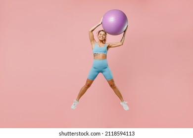 Full Body Young Strong Sporty Athletic Fitness Trainer Instructor Woman Wear Blue Tracksuit Spend Time In Home Gym Hold Fitball Isolated On Pastel Plain Light Pink Background. Workout Sport Concept