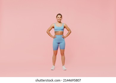 Full body young strong sporty athletic fitness trainer instructor woman wear blue tracksuit spend time in home gym hold hands on waist isolated on pastel plain pink background. Workout sport concept - Powered by Shutterstock