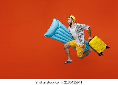 Full body young traveler tourist man in summer clothes hat hold suitcase inflatable mattress run isolated on plain orange background Passenger travel abroad weekend getaway. Air flight journey concept - Shutterstock ID 2185415641