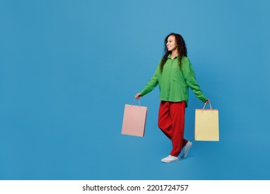 Full Body Young Woman Of African American Ethnicity 20s She Wear Green Shirt Holding Package Bags With Purchases After Shopping Walk Isolated On Plain Blue Background Studio. People Lifestyle Concept