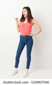 Full Body Young Woman On White Background Pointing To The Side