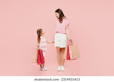 Full body young woman wearcasual clothes with child kid girl 6-7 years old hold shopping bag walk Mother daughter isolated on plain pink background. Black Friday sale buy day, family parent concept - Powered by Shutterstock