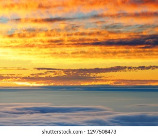Full color sunset over a sea of clouds, foreground in shade, cloud pattern, research station at the edge of the picture - Location: Hawaii, Maui Island, Haleakala Volcano