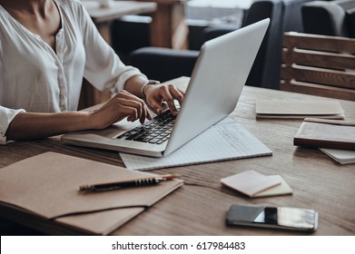 Full Concentration At Work. Close-up Of African Woman Using Computer While Sitting In Cafe