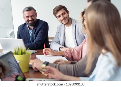 Full concentration at work. Group of young business people working and communicating while sitting at the office desk together - Shutterstock ID 1323093188