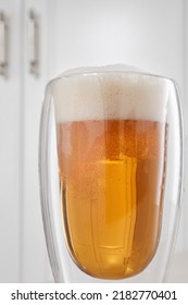 Full Double Wall Glass Of Light Lager Beer In A Home Interior. Selective Focus