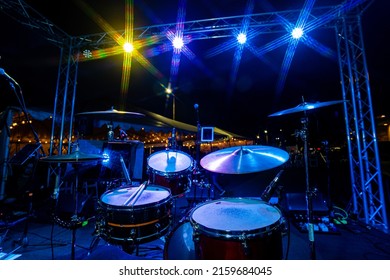 Full Drum Set Kit At Live Outdoor Music Show At Night With Microphone And Yellow Cool Blue Lights Nightlife