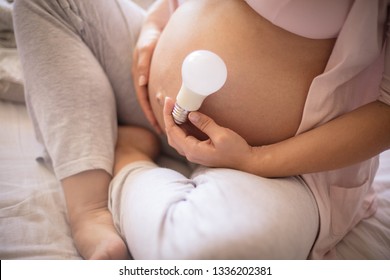 I'm Full Of Energy Because They Get The Light In My Life. Pregnant Woman Holding Light Bulb.