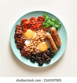 Full English Breakfast With Fried Egg, Bacon, Sausage, Beans And Mushrooms On Light Background. Top View, Flat Lay