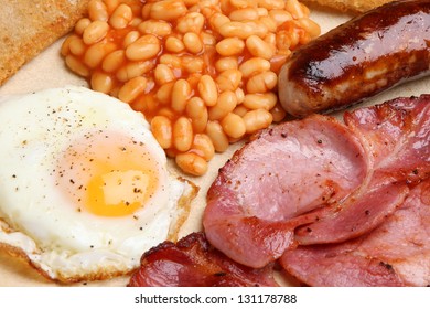 Full English Cooked Breakfast With Bacon, Sausage, Fried Egg And Baked Beans.