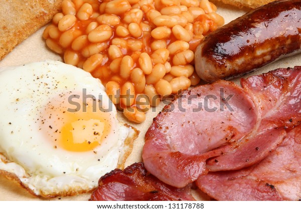 Full English cooked breakfast with bacon, sausage,\
fried egg and baked beans.