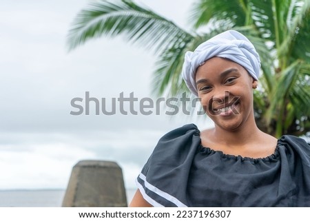 Full face portrait of a Nicaraguan Caribbean Afro-descendant woman smiling and looking at camera with copy space