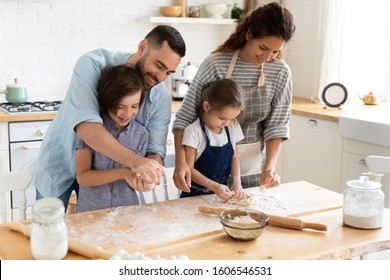 Full family feels happy cooking together gathered in domestic kitchen preparing family recipe pie or dessert, playful siblings helping to parents, mom and dad teaching kids, hobby and pastime concept - Shutterstock ID 1606546531