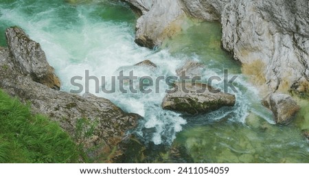 Full flowing mountain river with rapids. Clear water stream flow in rocky gorge of Austria. Spring nature landscape.