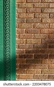 Full Frame Abstract Texture Background Of A Vintage Textured Brown Brick Wall Bordered With Intricate Green Painted Wood Moulding