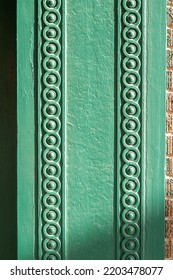 Full Frame Abstract Texture Background Of A Vintage Textured Brown Brick Wall Bordered With Intricate Green Painted Wood Moulding