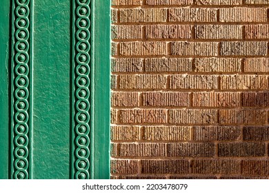 Full Frame Abstract Texture Background Of A Vintage Textured Brown Brick Wall Bordered With Intricate Green Painted Wood Moulding