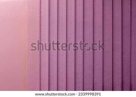 Full frame abstract texture background of a vertical blinds curtain in a gradient shade of deep pink