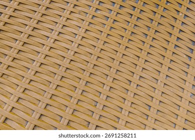 Full frame abstract texture of diagonal woven synthetic plastic rattan strips in warm brown. Ideal for wicker background, furniture, or seamless craft patterns.