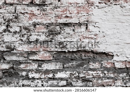 Full frame of aged multi-colored red black and white painted brick wall.