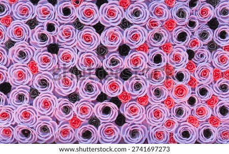 Full frame background of artificial pink and purple roses arranged as a decorative floral wall
