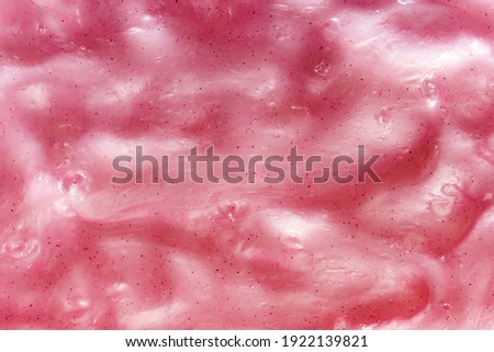 Full frame background of gooey pink slime, a kids toy produced with guar gum with an amorphous malleable squishy slimy texture in close up detail