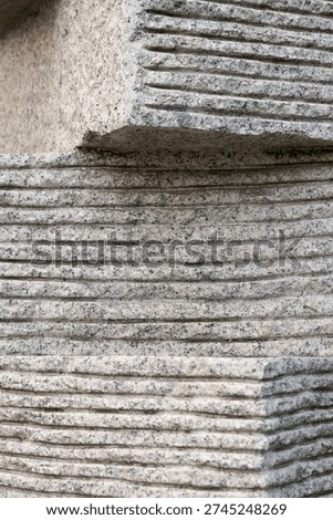 Full frame background of light grey granite stone with horizontal grooved lines.       