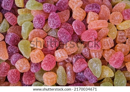 Full frame background of many multicolored gumdrops covered with sugar and placed in heap