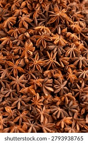 Full frame background pattern of organic whole star anise pods. Top view texture of aromatic oriental spice, perfect for food design and layouts