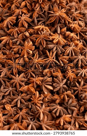 Full frame background pattern of organic whole star anise pods. Top view texture of aromatic oriental spice, perfect for food design and layouts