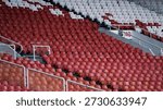Full frame background of repeating white stadium seats with red numbered stickers at Gelora Bung Karno (GBK) Stadium.