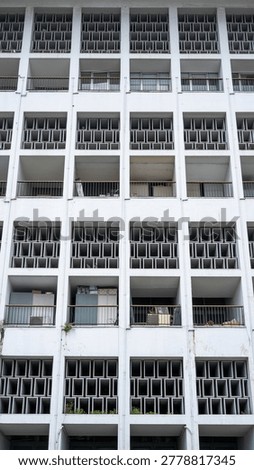 Full frame background of repetitive square balcony patterns on a white modernist building facade.