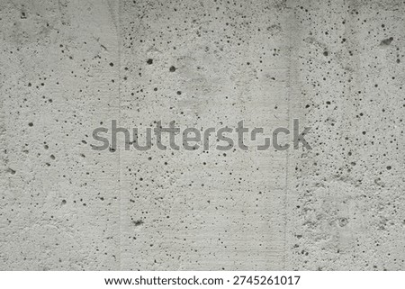 Full frame background of rough grey exposed concrete wall texture.