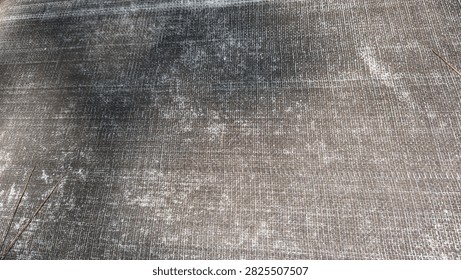 Full frame background texture of dark gray woven plastic ground cover mat with crosshatch pattern