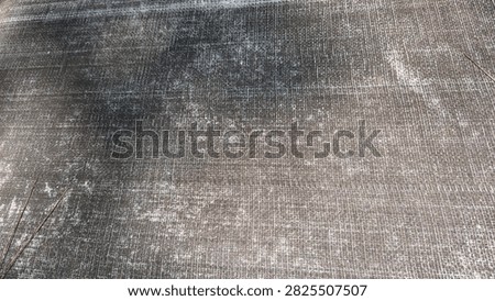 Full frame background texture of dark gray woven plastic ground cover mat with crosshatch pattern