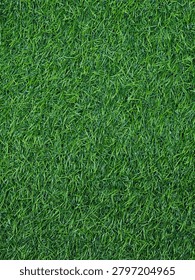 Full frame background texture of lush green artificial grass turf from a high angle top view.