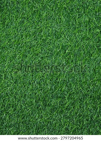 Full frame background texture of lush green artificial grass turf from a high angle top view.