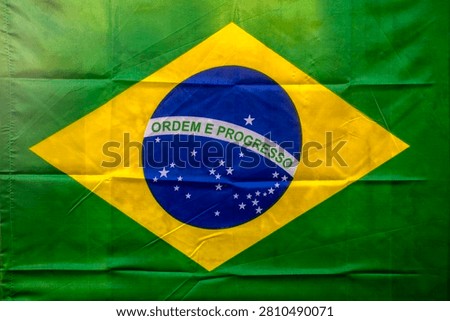 Full frame background texture of the vibrant green and yellow national flag of Brazil featuring the blue celestial globe with the motto Ordem e Progresso.