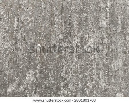 Full frame background texture of weathered rough concrete surface with grunge stains. A close-up view of a rustic unpainted concrete wall surface showing aged atmospheric grunge stains during daytime.