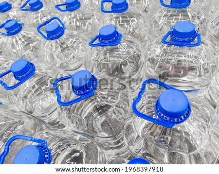 full frame background of transparent plastic 5 liter bottles of clear water