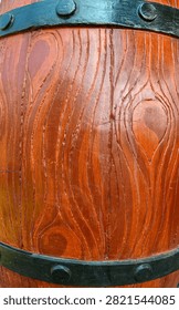 Full frame close up texture of brown carved wood pattern on a rustic barrel with black iron bands and rivets.