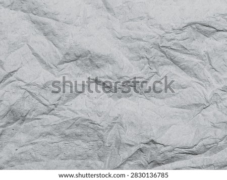 Full frame close-up background texture of wrinkled white tissue paper with creases and folds.