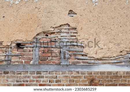 Full frame close-up on a half-timbered brick wall covered with daub.