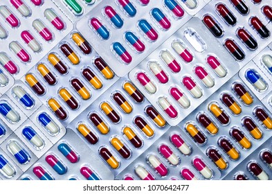 Full frame of colorful antimicrobial capsule pills. Quality control error in pharmaceutical manufacturing. Blister pack missing one capsule of antibiotic pill. Drug resistance. Defective concept.