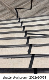 Full Frame Cut Out View Of Outside Downward Stairs With The Handrail Casting A Jagged Shadow Line