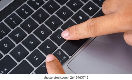 Full frame of finger pressing command and V letter button or cmd + V on a laptop keyboard, shortcut keys for paste isolated on black background